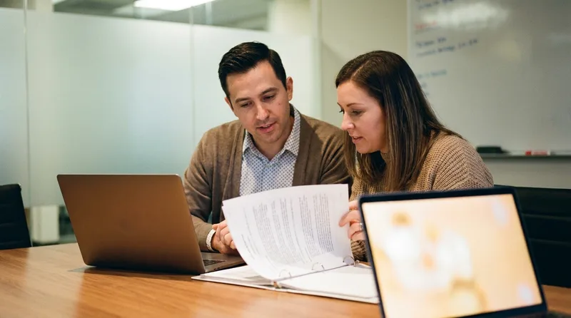 Dentist and office manager reviewing aftercare sheets together to approve the post-op call script
