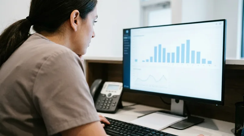 Front desk team member reviewing a call activity dashboard with hourly call bars on a monitor
