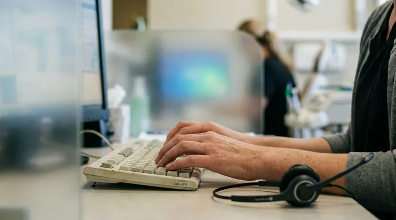 Dental office staff member verifying caller identity before discussing prescription details by phone