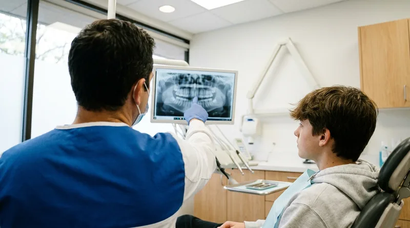 Dentist showing a teen where wisdom teeth are developing on a panoramic X-ray