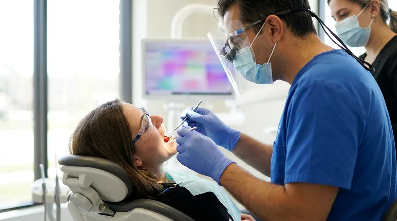 Dentist examining a patient veneer during a checkup