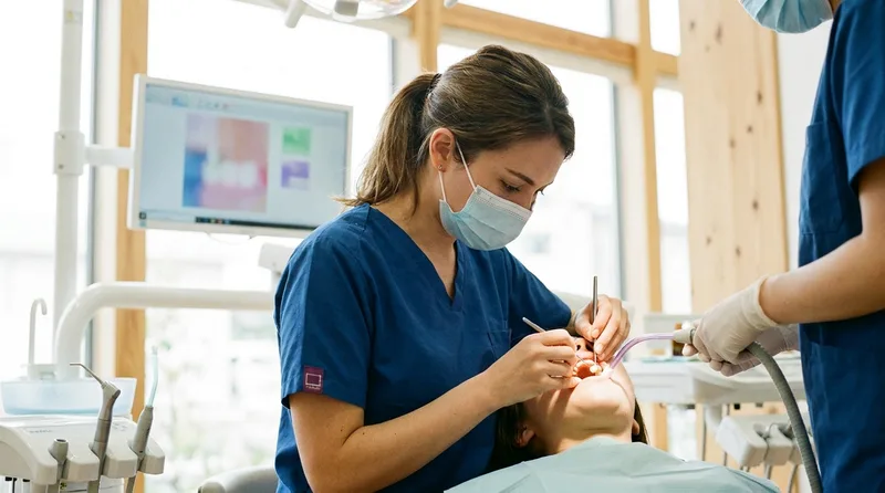 Dentist placing a crown on a tooth following root canal treatment