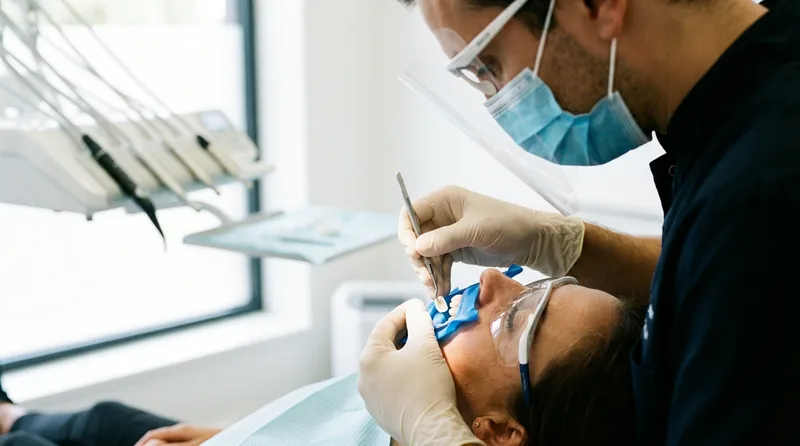 Dentist bonding a porcelain veneer onto a patient tooth